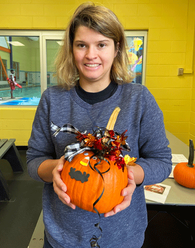 participant holding a decorated pumpkin