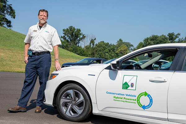 Man next to a hybrid car