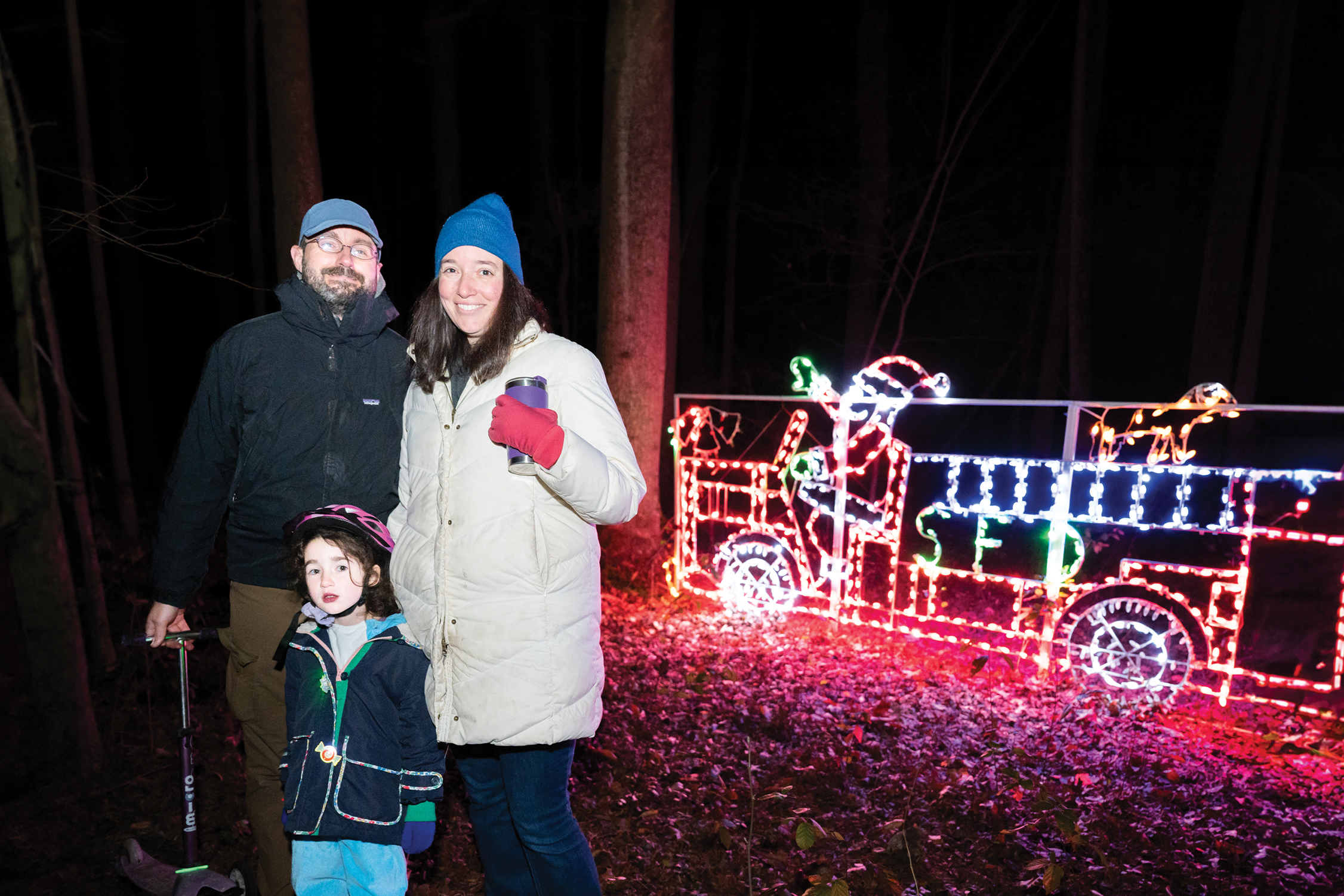 Family in front of holiday lights