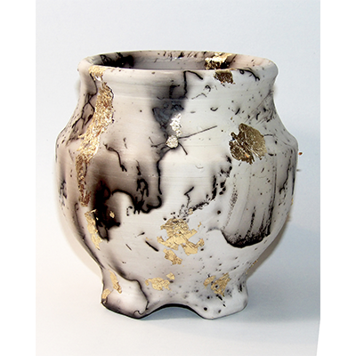 A black and white ceramic pot with gold leaf details