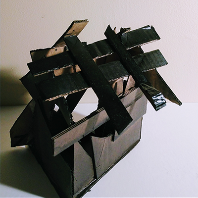 A spraypainted cardboard structure against a white background