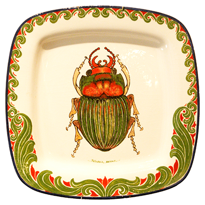 A detailed rounded square ceramic plate with a green and red beetle, and wave-like details around the lip of the plate.