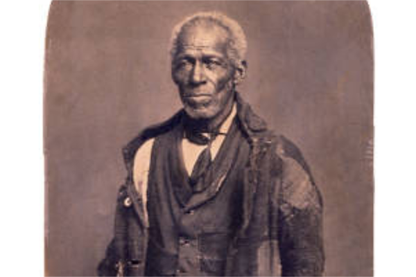 Cropped sepia-toned, historical portrait of a man with gray hair and well-worn, patched and mended clothing.