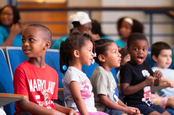 children watching a performance happily