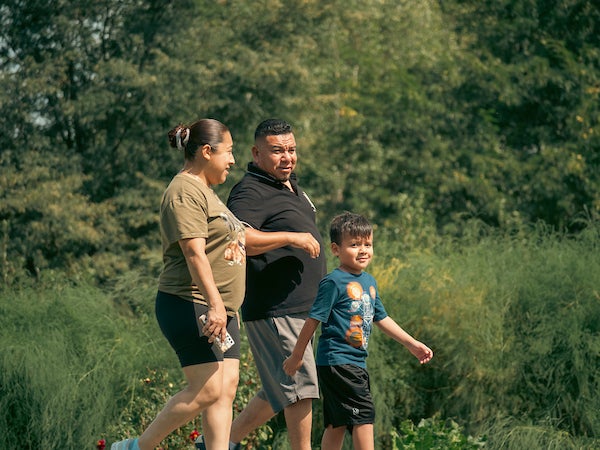 A family of three walking in a park