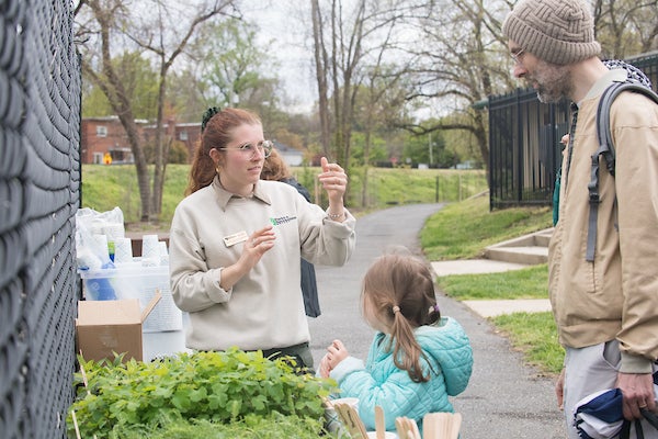 A woman speaking with a man and a child