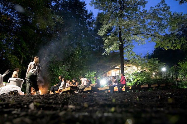 People sitting around a campfire on benches