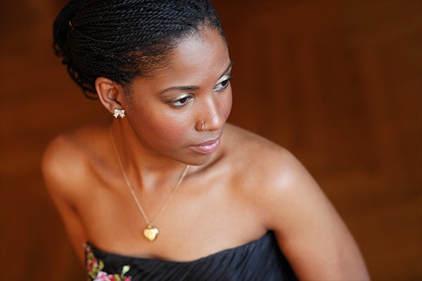 Headshot of a woman in a strapless gown wearing a gold necklace.